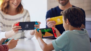 young boy plays Super Mario Maker 2 on the Nintendo Switch with his family