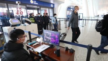 Staff members take passengers' body temperature at Tianhe International Airport in Wuhan, capital of central China's Hubei Province, Jan. 21, 2020