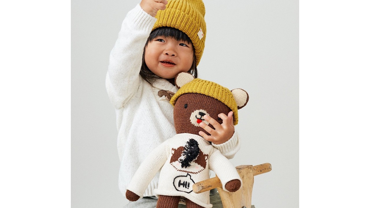 young girl holding bear with matching toque