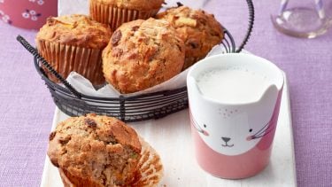 basket of muffins with a glass of milk