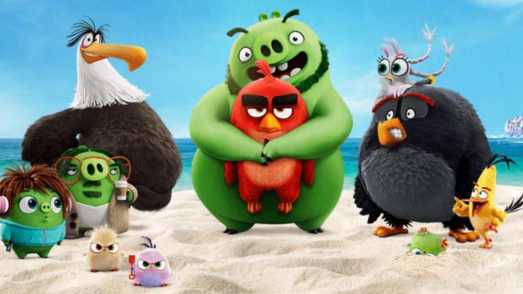 animated birds and pigs pose on a beach