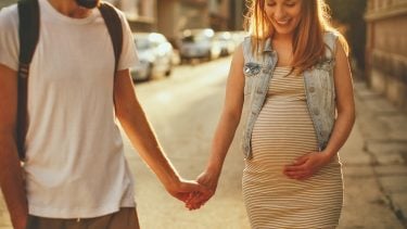 pregnant lady holding hands with a man