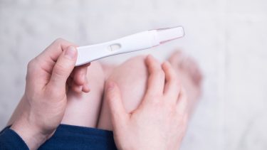 3 weeks pregnant: woman looking down at pregnancy test