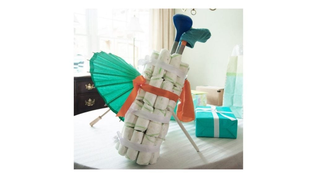 Diapers shaped into a golf bag with golf clubs sticking out of the top