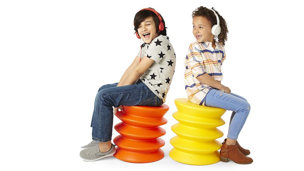 two kids sitting on colourful stools