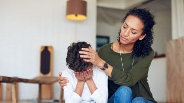 Mother comforting and teaching son how to stop bullying