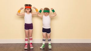 two kids posing inside while wearing athletic wear and sweatbands