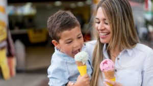 Mother and son eat ice cream together.