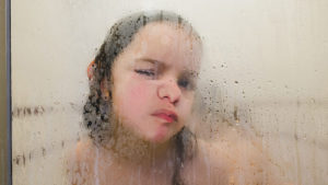 Kid in tub learning how to transition from baths to showers