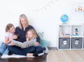 mom reading to two girls in Montesssori-style playroom