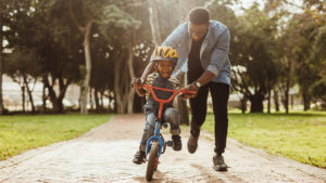 Dad teaching child to ride a bike