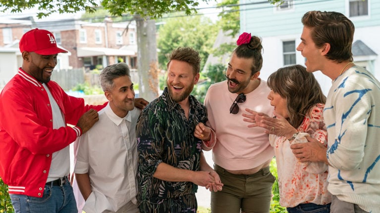 the Queer eye team standing and laughing with one of their subjects