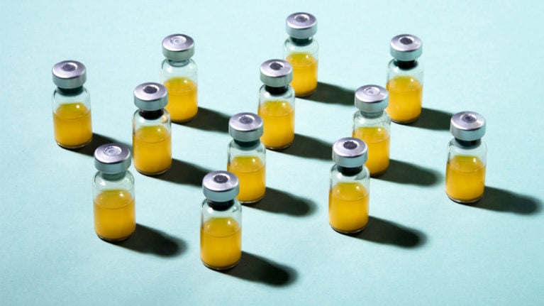 vials lined up in a grid and filled with yellow liquid