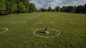 young girl sitting inside a park circle during the pandemic