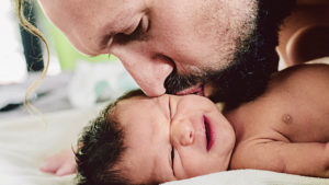 Kissing baby's cheek after dad struggling to bond with baby