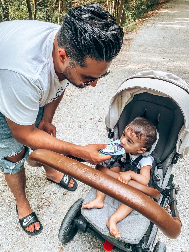 Dad feeding baby in stroller