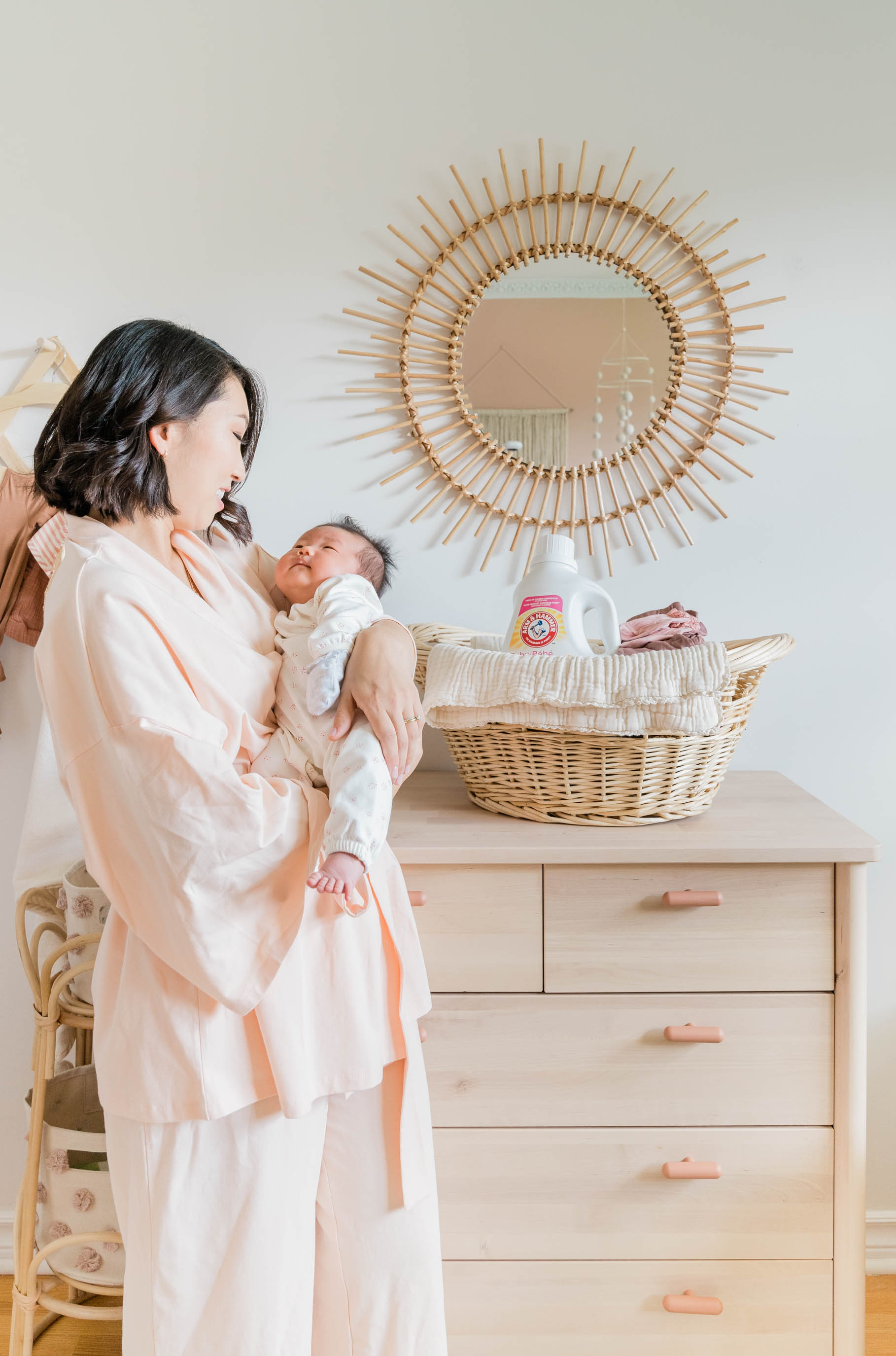 Esther Lee holding baby with laundry detergent in basket