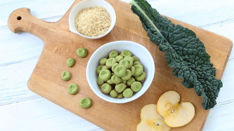 baby food recipes green baby puffs on a wooden cutting board with kale, rice and apple slices