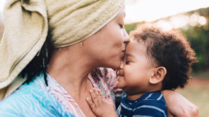 Black mother kissing her baby on the forehead