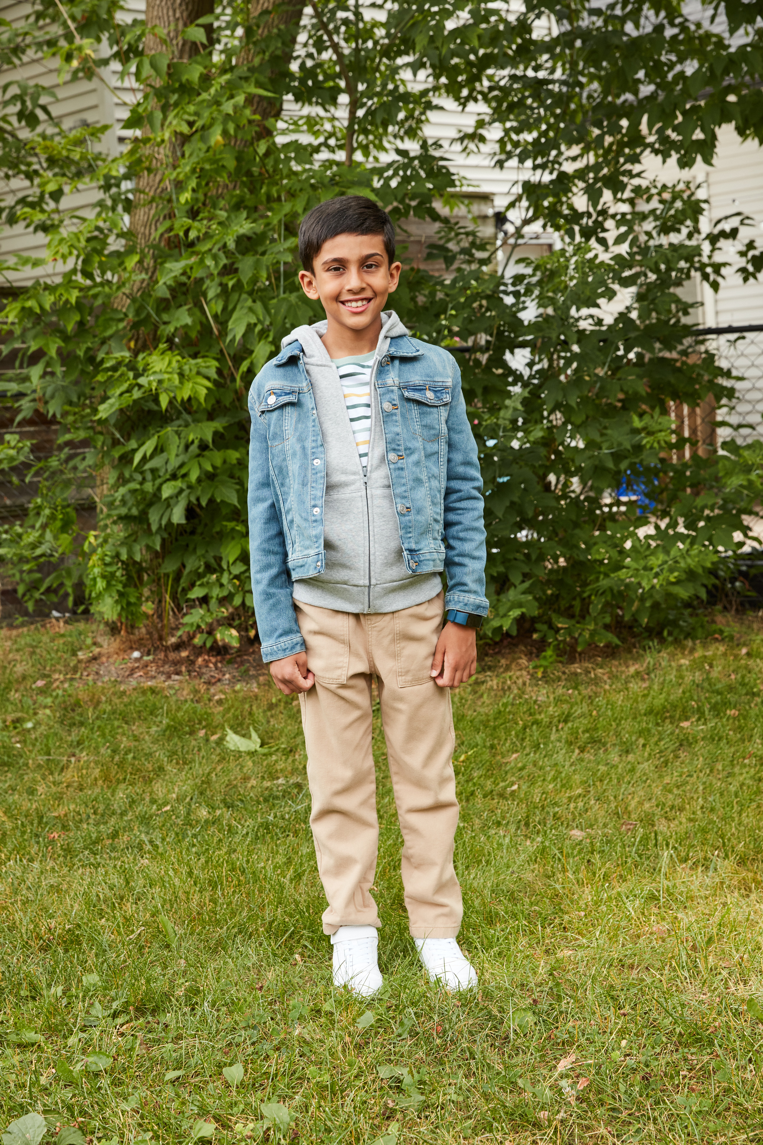 Young boy wearing hoodie and denim jacket outside