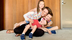 Author Susie Allison of Busy Toddler plays on the ground with her children