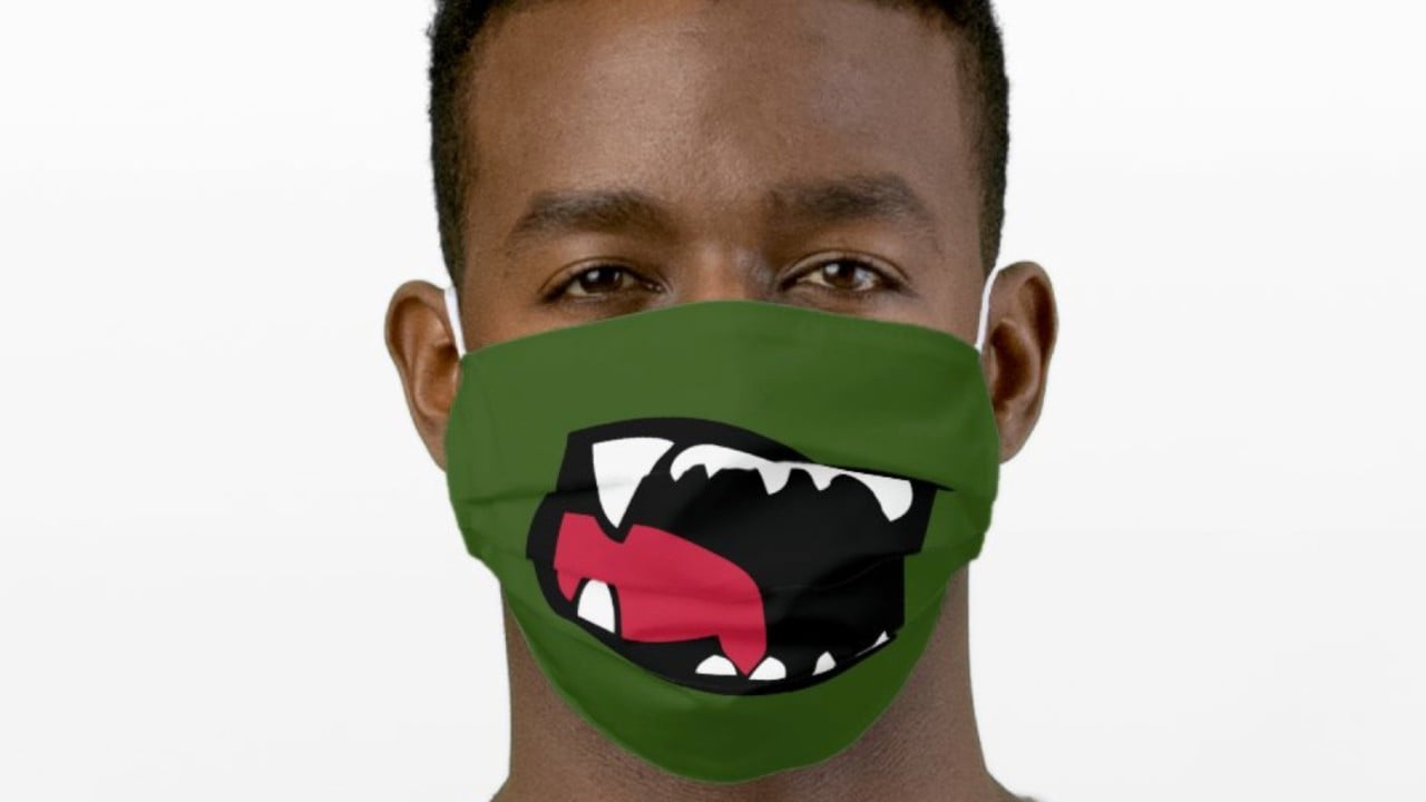 young man wearing green dinosaur smile