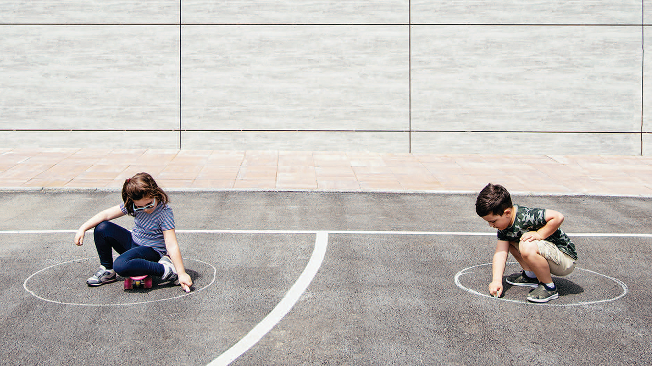 two young children doing chalk drawings
