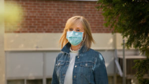 Middle school teacher Laura Thomson stands in front of school during coronavirus