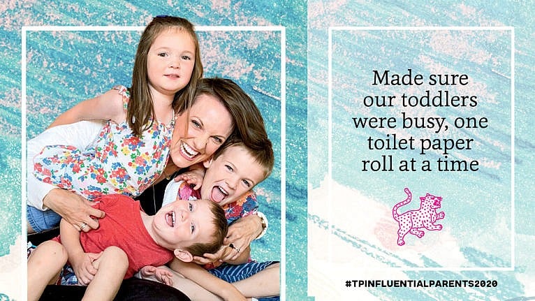 Susie Allison of Busy Toddler poses with her three kids on her lap beside the text 'made sure our toddlers were busy, one toilet paper roll at a time'