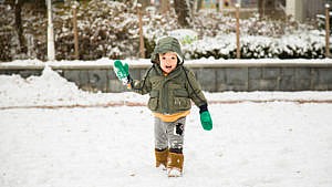 photo of a toddler playing in the snow