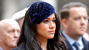 Meghan Markle wears a blue hat with a net at a remembrance day ceremony