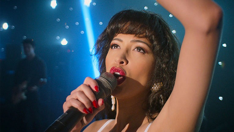 A still from Selena: The Series showing a pop star singing on a stage