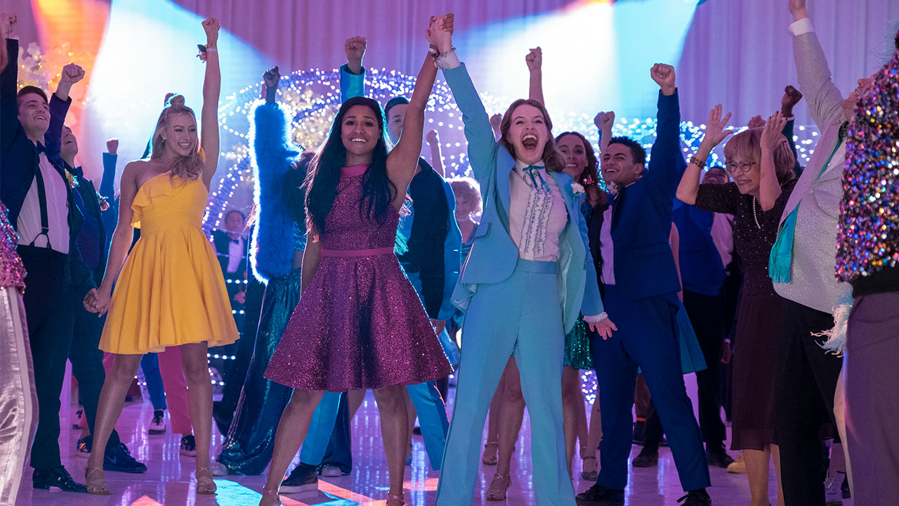 A still from The Prom showing a group of teens cheering on a lesbian couple at a prom