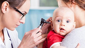 doctor looking in baby's ear
