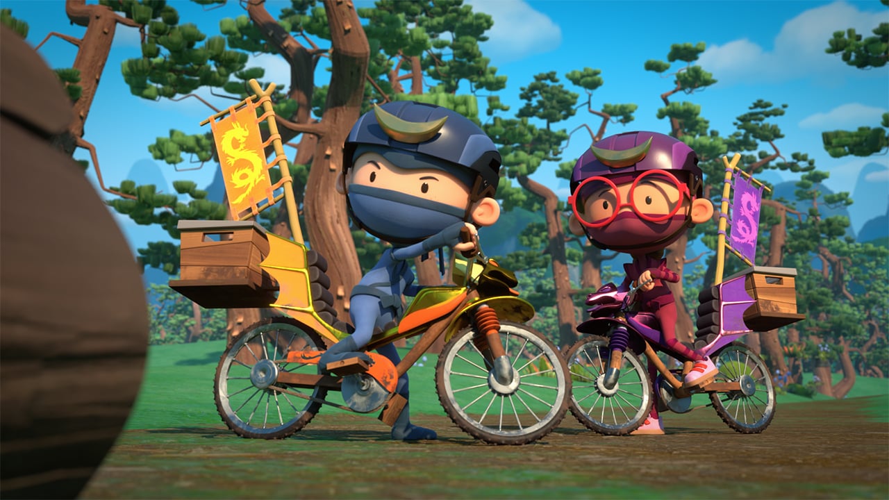 A still from the animated show Hello Ninja showing two kids in Ninja costumes riding their bikes through a forest
