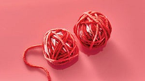 Photo of two small balls of yarn in red and pink tones