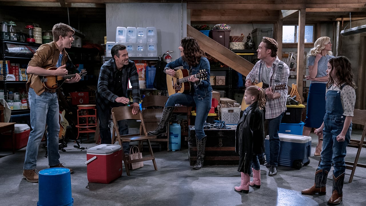 Still from the show Country Comfort showing a family band rehearsing in their basement