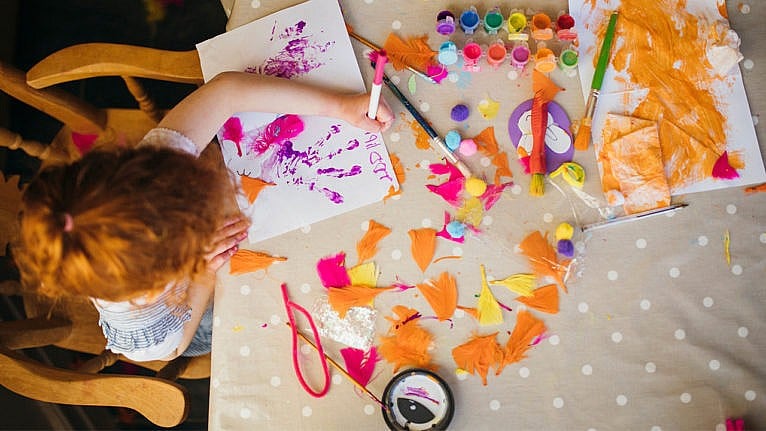 Overhead photo of a kid doing a messy painting craft