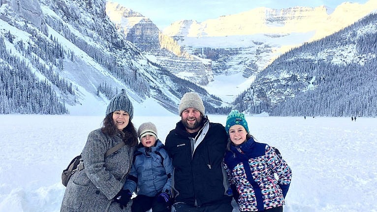 Photo of the author and their family posing for a picture at Lake Louise in the winter