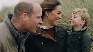 Still from a video posted for Will and KAte's anniversary showing the couple laughing with their youngest kid while sitting by the shore