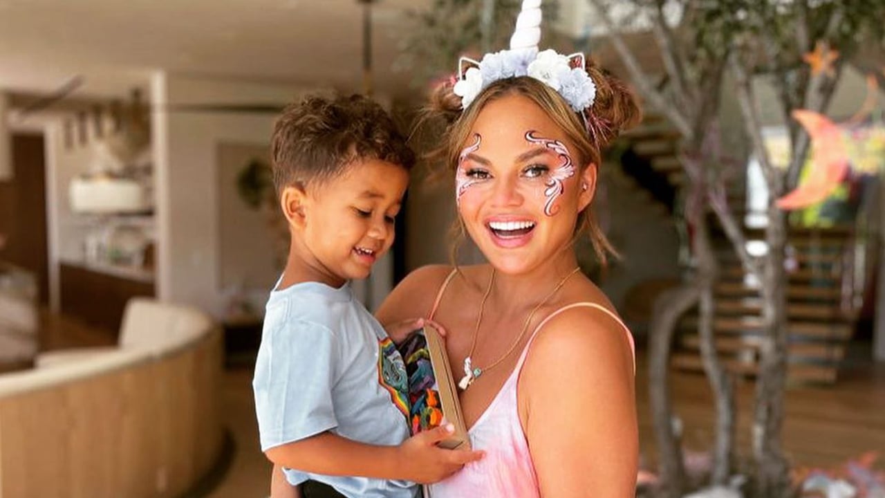 Photo of Chrissy and her son Miles dressing up as unicorns in front of the tree in their house