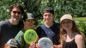 The Trudeau family poses with frisbees outside