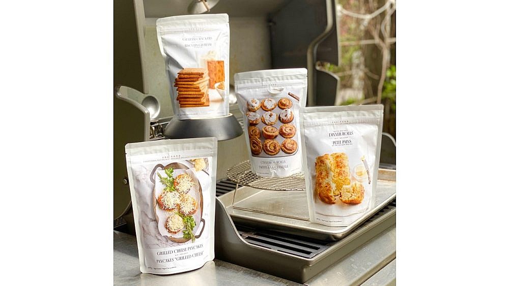 Four packages of baking mix arranged on an outdoor grill
