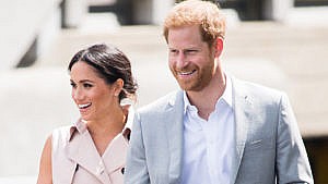 Prince Harry and Meghan smile while walking in London