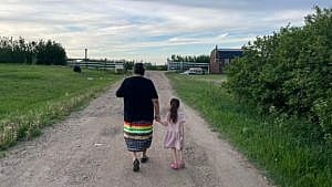 a grandmother and granddaughter walking hand-in-hand
