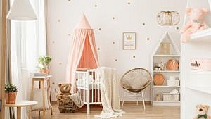 a decorated nursery with a crib, chair, bookshelf and toys