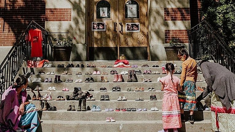 kids' shoes lined up in front of a cathedral