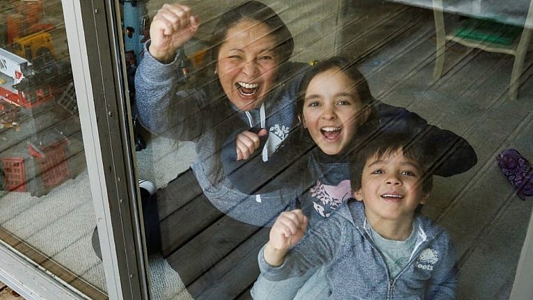 a mom and her two kids through a window