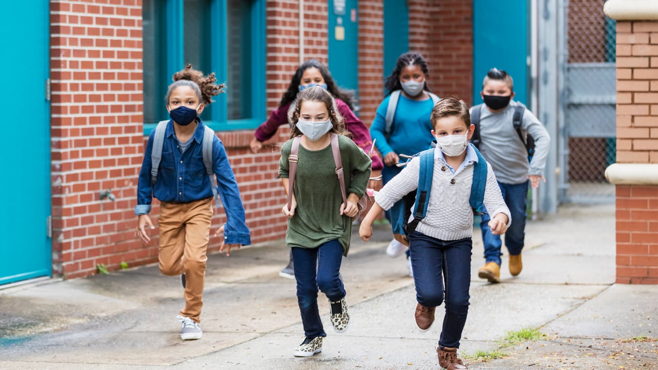 kids in masks leaving school for the day
