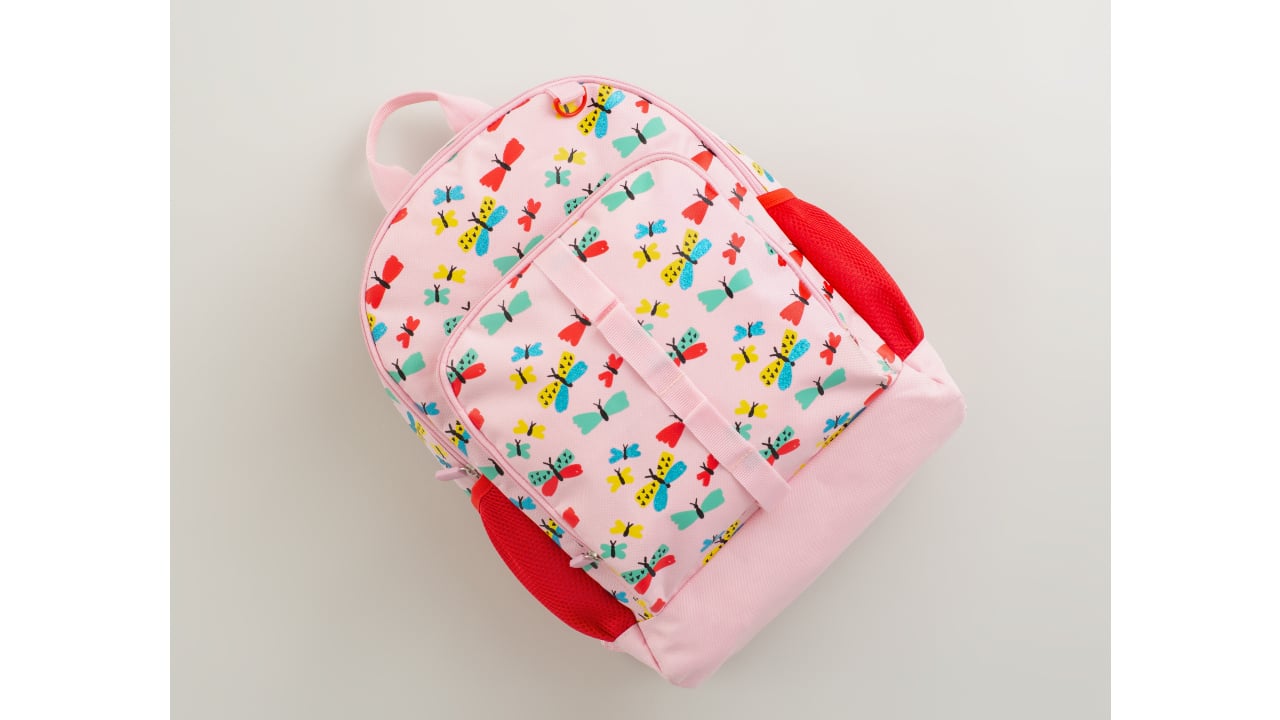 Pink backpack with colourful butterflies and red accents